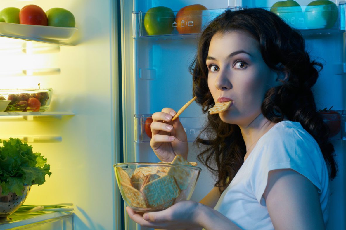 Woman eating from the fridge